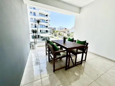a dining room with a table and chairs on a balcony at Bright & cozy apartment in Livadia in Livadhia