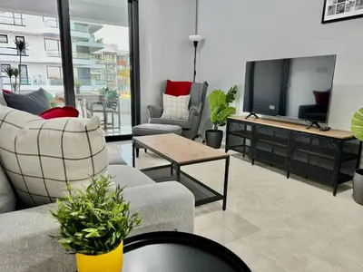 a living room with couches and a flat screen tv at Bright & cozy apartment in Livadia in Livadhia