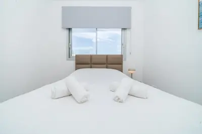 a white bedroom with a large bed and a window at New 2 bedroom flat in Aglantzia in Aglantzia