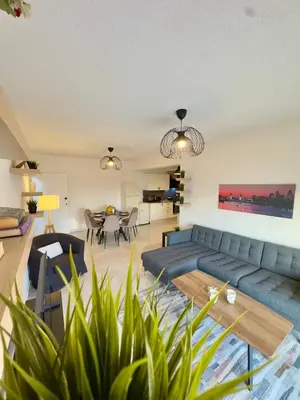 a living room with a blue couch and a table at Napa Skyline Suite 3BR Sunset Views and Pool in Ayia Napa