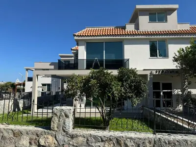 a large white house with a stone wall at Veray Homes, Alsancak in Ayios Dhometios