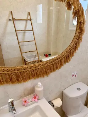 a bathroom with a mirror and a toilet and a sink at Rope and Reef 2BD Walk to Nissi Beach and Pool in Ayia Napa