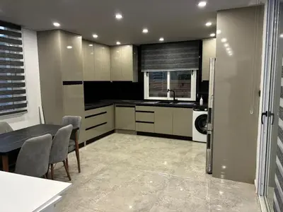 a kitchen with white cabinets and a table with chairs at Veray Homes Villa in Ayios Dhometios