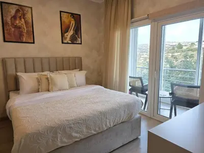 a bedroom with a large bed and a balcony at White Arches Haven by Staycom in Limassol