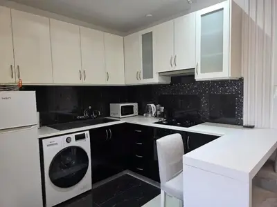 a kitchen with white cabinets and a washing machine at White Arches Haven by Staycom in Limassol