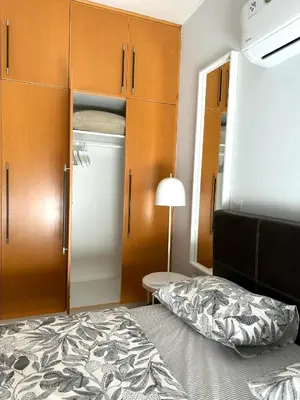 a bedroom with a bed and wooden cabinets and a closet at Blue Edge Makenzy in Larnaka