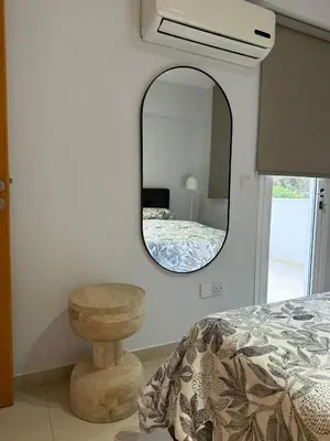 a bedroom with a mirror and a bed and a table at Blue Edge Makenzy in Larnaka