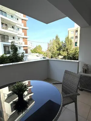 a balcony with a glass table and a chair at Blue Edge Makenzy in Larnaka