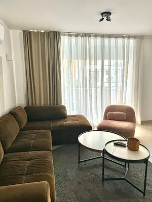 a living room with a couch and a table and a chair at Blue Edge Makenzy in Larnaka