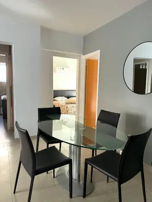 a dining room with a glass table and chairs at Blue Edge Makenzy in Larnaka