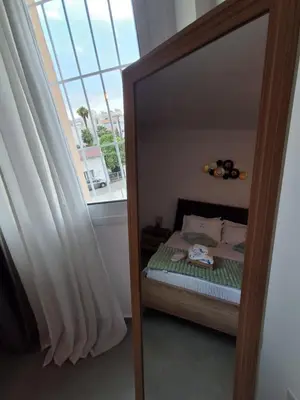a mirror in a bedroom with a bed and a window at Lazuli City Center Ap 11 in Larnaka