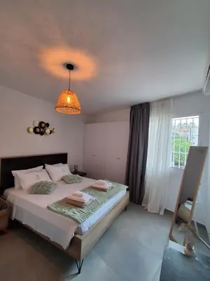 a bedroom with a large bed and a chandelier at Lazuli City Center Ap 11 in Larnaka