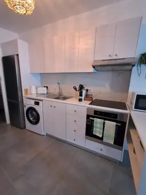 a kitchen with a stove and a sink and a refrigerator at Lazuli City Center Ap 11 in Larnaka