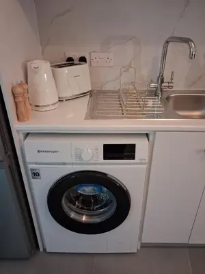 a washing machine in a kitchen with a sink at Lazuli City Center Ap 11 in Larnaka
