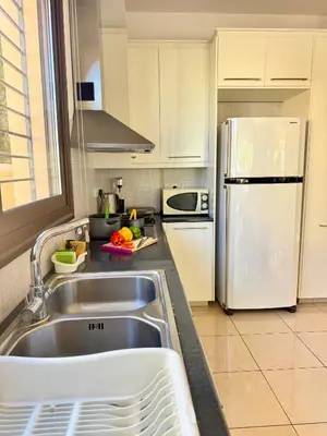 a kitchen with a sink and a white refrigerator at Aurora Gardens Villa Spacious 3 Bedroom in Protaras in Paralimni
