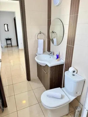 a bathroom with a toilet and a sink and a mirror at Aurora Gardens Villa Spacious 3 Bedroom in Protaras in Paralimni