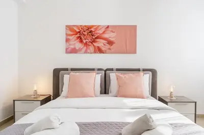 a bedroom with a large bed with pink pillows at Averna - Breezy 2-BR Apt & Balcony in Larnaca in Larnaka