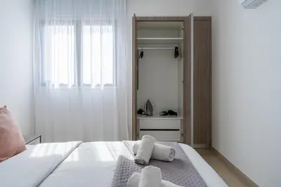 a bedroom with a bed with towels on it at Averna - Breezy 2-BR Apt & Balcony in Larnaca in Larnaka