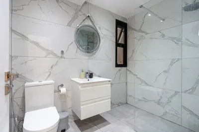 a white bathroom with a toilet and a mirror at Averna - Breezy 2-BR Apt & Balcony in Larnaca in Larnaka