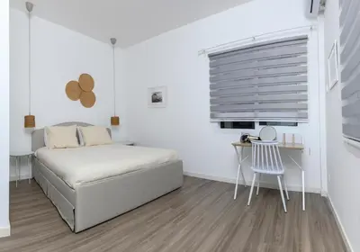 a bedroom with a bed and a table and a chair at Bright 2BR by Pedieos Park, near Old Town in Nicosia