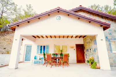 a house with a patio with a table and chairs at Gazingstars Cottages Agridia