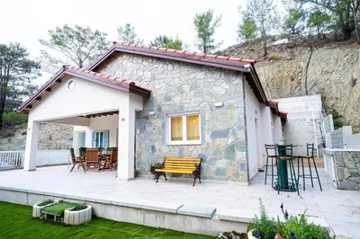 a small stone house with a patio at Gazingstars Cottages Agridia