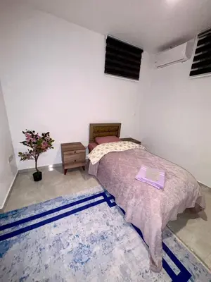 a bedroom with a bed and a table and a rug at Lapta Purple 2 bedroom in Peristerona