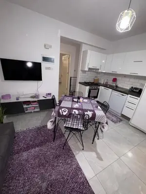 a living room with a table and a kitchen at Lapta Purple 2 bedroom in Peristerona