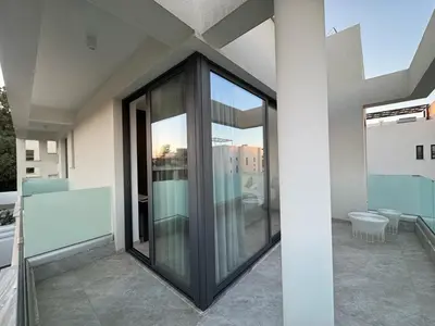 a balcony with glass doors on a building at Sunrise Pearl - 2 min walk to Sirena Bay in Paralimni