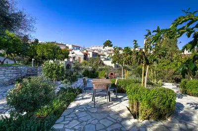 a patio with a table and chairs in a garden at Horizon View Lefkara with Pool, Garden, Parking in Pano Lefkara