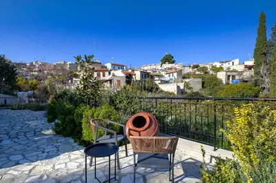 a patio with chairs and tables and a city at Horizon View Lefkara with Pool, Garden, Parking in Pano Lefkara