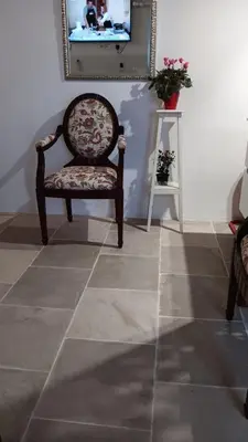 a chair in a room with a tile floor at Cecilia Traditional House-Suites in Kalopanayiotis