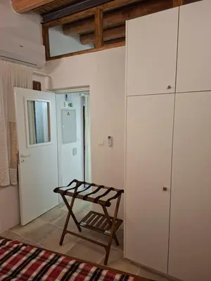 a room with a chair and a white cabinet at Cecilia Traditional House-Suites in Kalopanayiotis