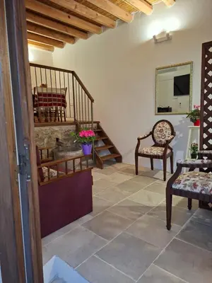 a living room with a staircase and a chair at Cecilia Traditional House-Suites in Kalopanayiotis
