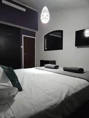 a bedroom with two beds and a chandelier at Serenity Home - Holiday Apt Larnaca in Larnaka