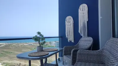 two chairs and a table on a balcony with a view of the ocean at Studıo Iskele 150 in Aglantzia