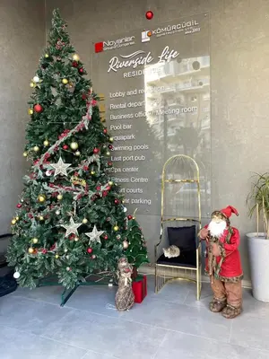 a child standing in front of a christmas tree at Studıo Iskele 150 in Aglantzia