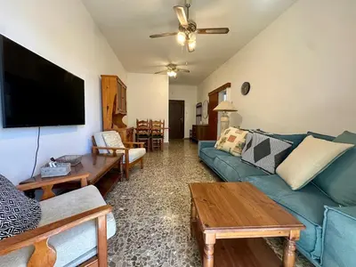 a living room with a blue couch and a flat screen tv at 2 bedroom flat by the sea in Larnaka
