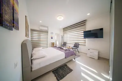 a bedroom with a bed and a desk and a television at Villa Oro Hills w private hot tub jacuzzi in Voroklini