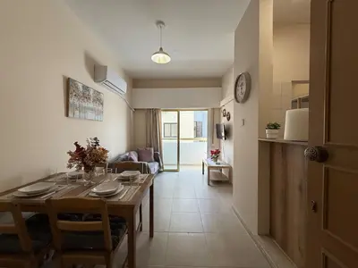 a dining room and living room with a table at One-bedroom apartment next to Radisson Blu in Larnaka