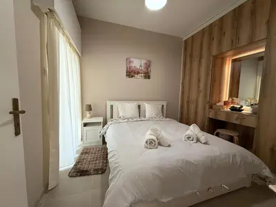 a bedroom with a white bed with towels on it at One-bedroom apartment next to Radisson Blu in Larnaka