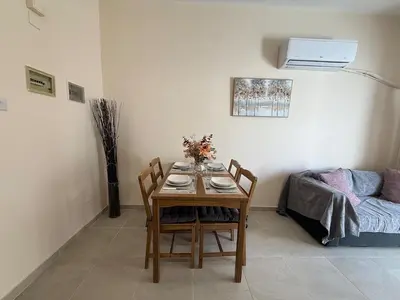 a dining room with a table and chairs and a couch at One-bedroom apartment next to Radisson Blu in Larnaka