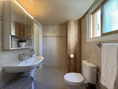a bathroom with a sink and a toilet and a window at One-bedroom apartment next to Radisson Blu in Larnaka