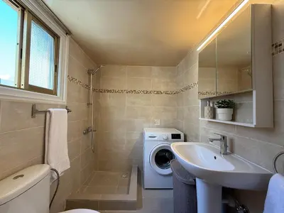 a bathroom with a washing machine and a sink at One-bedroom apartment next to Radisson Blu in Larnaka