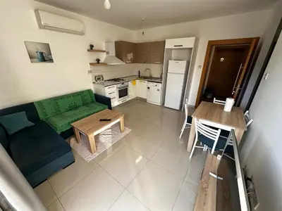 a living room with a green couch and a table at Avrasya site, Luxury one-bedroom apartment in Kyrenia city center