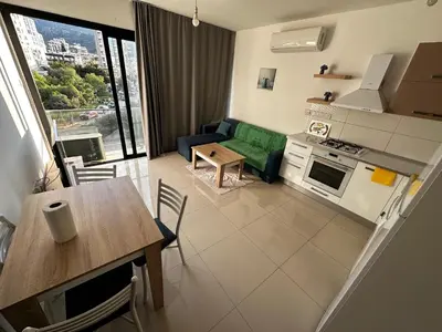 a small living room with a table and a kitchen at Avrasya site, Luxury one-bedroom apartment in Kyrenia city center