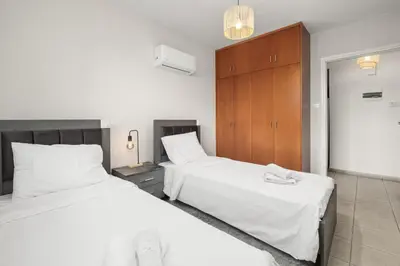 a bedroom with two beds with white sheets at Downtown Stadium 3 Bedroom Apartment in Larnaka