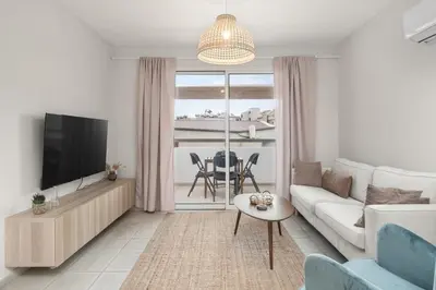 a living room with a couch and a tv and a table at Downtown Stadium 3 Bedroom Apartment in Larnaka