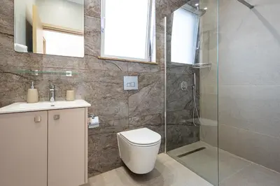 a bathroom with a toilet and a glass shower at Chrystal Residences in Nicosia
