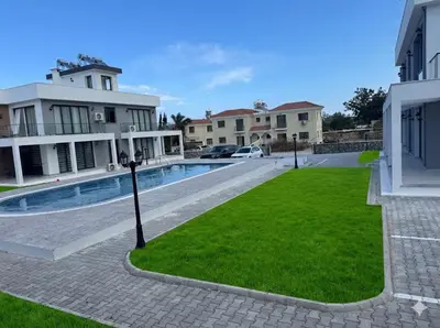 a villa with a swimming pool and green grass at Soğular Apartments 1 in Aglantzia